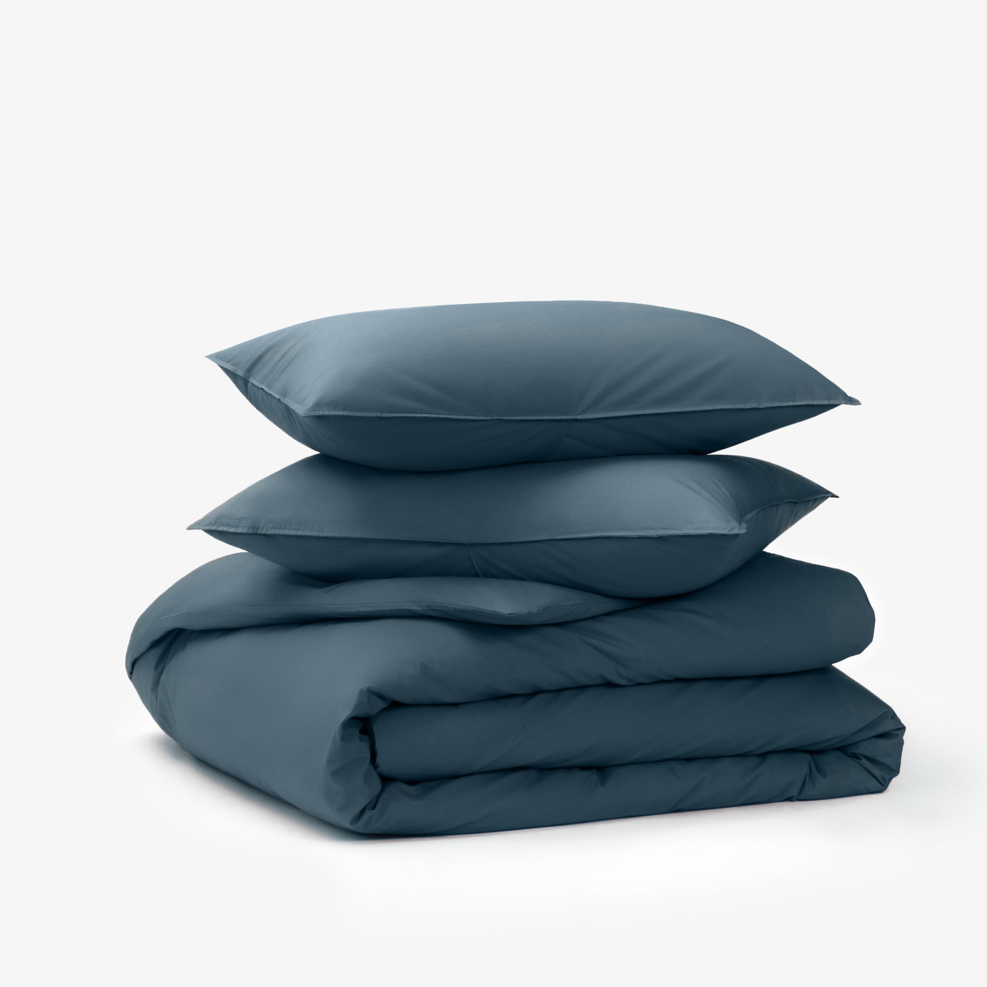 Canyon colored Duvet covers folded under 2 pillows with a canyon colored pillow case in front of a white background