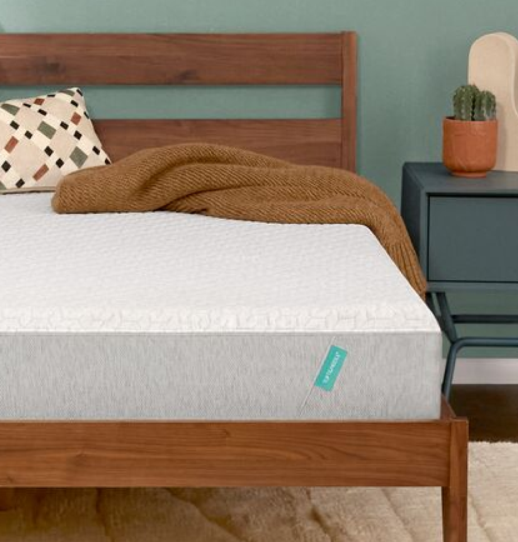 Tuft & Needle Original mattress on a wooden bed frame with a brown blanket and patterned pillow.