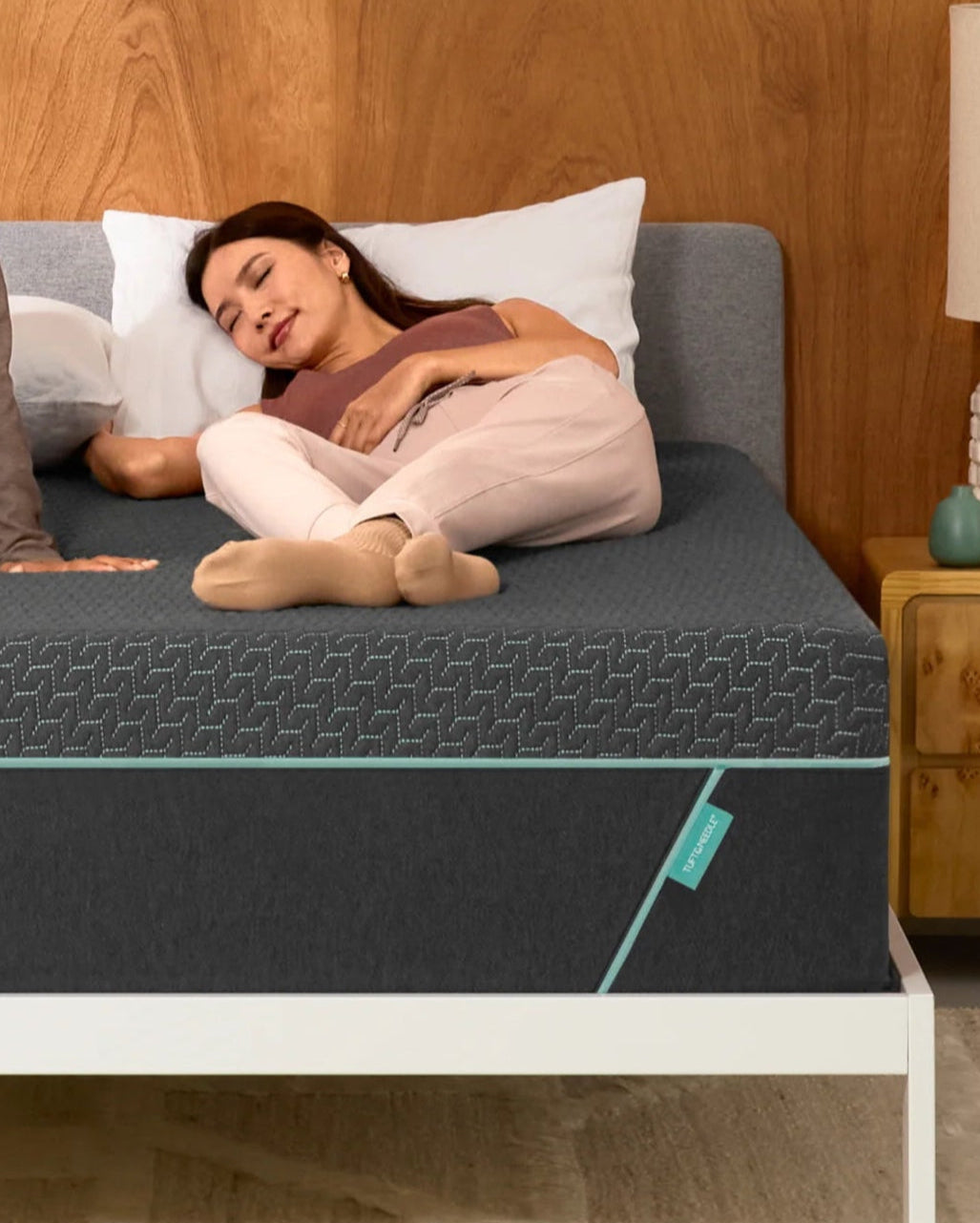 Woman lays on mint hybrid mattress