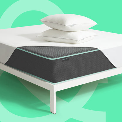 Tuft & Needle Original Hybrid Mattress II with mattress protector and two pillows on a white bed frame